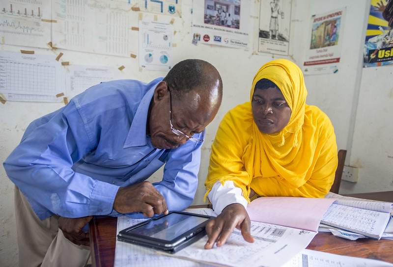 Two health center staff looking at a report. Photo Credit: PMI