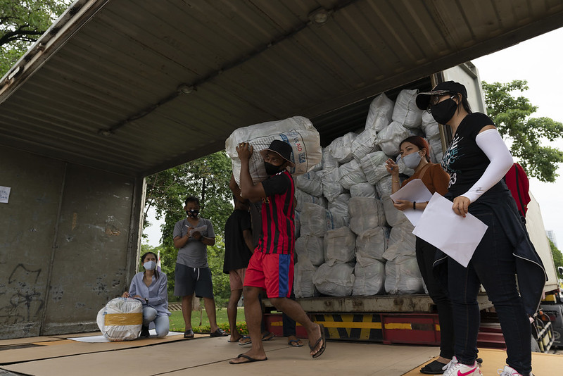 People unload packages of insecticide-treated nets from a distribution truck. Photo Credit: Permsak Tosawad for Inform Asia: USAID Health Research Program