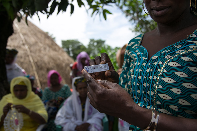 A woman holding a malaria rapid diagnostic test. Photo Credit: Patrick Adams/Flickr